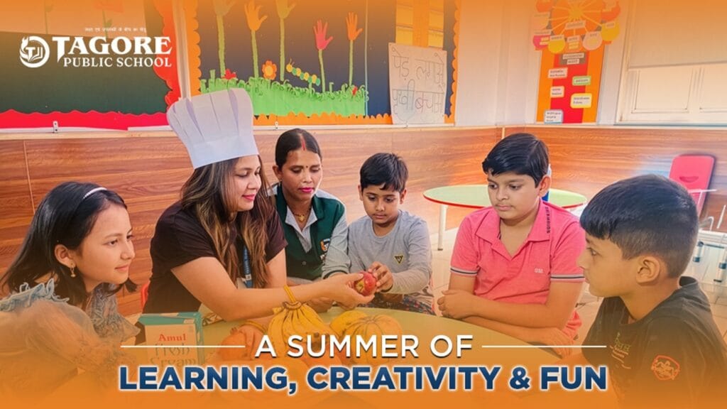 A female teacher wearing a white chef's hat holds up a red apple to show a group of five students sitting around a table. The table has various fruits and a box of fresh cream. Text on the image reads "Tagore Public School - A Summer of Learning, Creativity & Fun."
